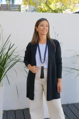 Saco abierto de punto color negro, con mangas largas y bolsillos frontales. Diseño de corte recto y largo medio.