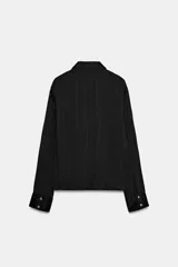 Camisa de manga larga con cuello solapa, confeccionada en tejido satinado con textura efecto arrugado y cierre frontal con botones.