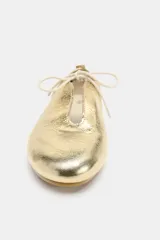 Zapato tipo bailarina de piel con acabado metalizado dorado, detalle de lazo frontal y tirador en el talón.