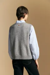 Chaleco tejido de punto en color azul marino, con diseño de textura sutil en relieve, escote redondo y terminaciones acanaladas en cuello, sisas y ruedo.