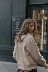 Sudadera de manga larga con capucha ajustable mediante cordones, bolsillo frontal tipo canguro y puños y ruedo en tejido rib.