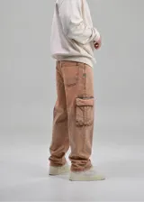 Pantalón cargo baggy color marrón con efecto desteñido, de corte holgado, tiro medio y bolsillos laterales con solapa en las piernas.