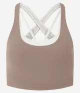 Top deportivo de microfibra marca Get Over, de diseño bicolor en tonos marrón y marfil, con escote redondo, capas superpuestas, breteles anchos cruzados y abertura en la espalda.