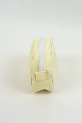 Neceser pequeño de color amarillo claro, con diseño acolchado y cierre superior blanco. Incluye una etiqueta con el logo de la marca Indian en el frente.