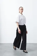 Pantalón wide leg de corte sastrero, color negro, con cintura de tiro medio y diseño de pernera amplia y relajada.