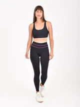 Calza deportiva negra con detalles de líneas finas en color fucsia en la cintura y los laterales.