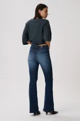 Jean oxford tiro bajo, color negro, de corte ajustado en la parte superior y con botamanga acampanada. Cuenta con bolsillos funcionales, pasacintos y cierre frontal con botón metálico.