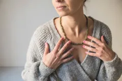 Collar de cuentas de jade verde de 6mm con separadores de hilo naranja y cierre de mosquetón de acero hipoalergénico.