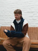 Buzo afelpado de hombre con diseño color block en marrón, azul y blanco.