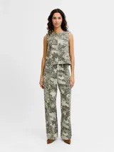 Pantalón de tiro alto, corte recto y amplio, confeccionado en sarga resistente con un estampado all-over camuflado en tonos verde militar y beige, con líneas verticales de pespuntes claros. Cuenta con cierre de cremallera y bolsillos delanteros y traseros.