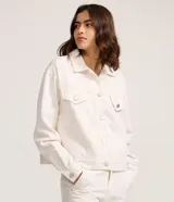 Campera trucker confeccionada en sarga de algodón color blanco, con cuello tradicional, cierre frontal de botones metálicos, bolsillos frontales con solapa y costuras reforzadas.