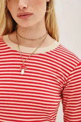 Remera de punto de manga larga con diseño de rayas horizontales en color rojo y beige, cuello redondo y ajuste cómodo.