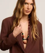 Blazer oversized de Marfinno color marrón, confeccionado en mezcla de viscosa, poliéster y lino. Presenta solapas clásicas en el cuello, cierre frontal abotonado y bolsillos delanteros.
