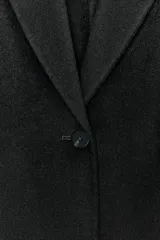 Blazer Zara de corte entallado confeccionada en mezcla de lana. Presenta cuello con solapa de muesca, manga larga y cierre frontal con un solo botón.
