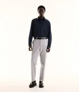 Pantalón de vestir gris claro, corte slim, con trabillas para cinturón, cierre tradicional, bolsillos laterales y traseros.