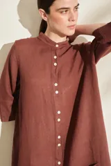 Túnica midi marrón de lino, con cuello mao, cierre frontal con botones y bolsillos laterales.