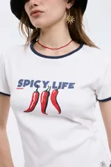 Remera baby blanca de algodón, de corte cropped al cuerpo y mangas cortas. Presenta ribetes negros en contraste en el cuello redondo y los puños, con un estampado localizado de un ají rojo con la inscripción 'Pimentón' en el centro del pecho.