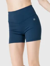 Calza corta deportiva color azul oscuro, con cintura alta en forma de V y logo blanco en el lateral. Incorpora banda de silicona para un ajuste seguro y tecnología Aloe Vera para mayor suavidad.