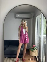 Conjunto color naranja compuesto por un chaleco sin mangas con solapas y un short de tiro alto con elástico en la parte trasera.