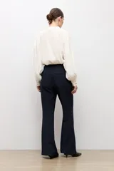 Pantalón sastrero de corte flare, color azul marino, con bolsillos laterales y trabillas para cinturón.