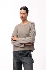 Remera de silueta amplia con hombro caído y cuello redondo, confeccionada en tejido suave de algodón. Presenta un diseño holgado y versátil con mangas largas.