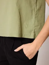 Musculosa de lino color verde claro, con cuello redondo y diseño holgado.