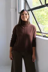 Sweater de punto color marrón chocolate, con cuello alto y costura central vertical en el frente. Presenta puños y ruedo acanalados.