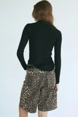 Bermuda de cinco bolsillos en denim de algodón rígido, con tiro alto, cierre y botón, y estampado animal print de leopardo.