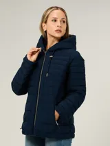 Campera ligera acolchada de corte entallado, con capucha ajustable mediante cordones, cierre frontal de cremallera y bolsillos laterales con cierre. Presenta un diseño de líneas horizontales y logo distintivo de la marca.