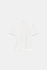 Remera blanca de manga corta y cuello redondo, de corte regular fit, con delicados detalles de bordados tonales en el frente.