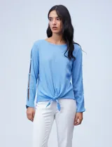 Blusa tejida color celeste con lurex, de manga larga con aberturas y apliques de brillo. Ruedo anudado.