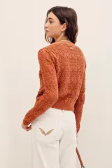 Cardigan cropped de punto calado color tostado, con escote en V, manga larga y cierre frontal con botones.