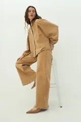 Jean wide leg de tiro alto y corte amplio, color camel, confeccionado en denim con efecto desgastado.