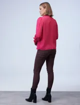 Blusa blanca de gasa con cuello a la base, escote en V y botones. Presenta punto smock en hombros y puños.