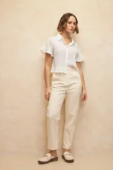 Pantalón de vestir color crema, de corte recto, con bolsillos laterales y traseros. Se ajusta a la cintura con dos botones.