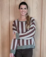 Buzo tostado de corte holgado con cuello redondo y manga larga. Presenta una estrella blanca estampada en la espalda y ribete marrón en cuello y ruedo.