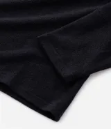 Camisa de pijama de manga larga confeccionada en tejido plush color negro, con cuello redondo y cierre frontal parcial con botones.