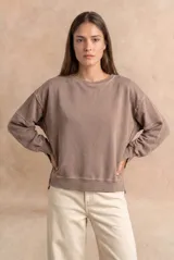 Sweater de algodón peinado con efecto lavado, de corte oversize, cuello redondo y mangas largas con costuras visibles.
