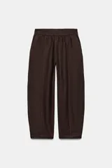Pantalón de lino marrón oscuro, de corte barrel con pernera holgada que se estrecha hacia el tobillo, cintura elástica y bolsillos delanteros.