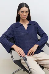 Sweater de punto calado en color azul, con cuello polo y escote en V. Presenta mangas largas con puños rectos y un diseño de tejido vertical.