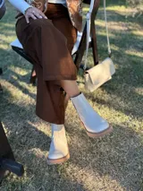 Bota corta de cuero vacuno con textura granulada, color crudo. Presenta cierre lateral metálico, tirador en la parte trasera y suela track de goma en tono contrastante.