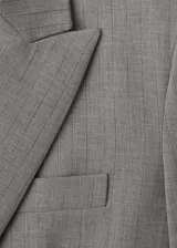 Blazer de corte recto y diseño estructurado, confeccionado en tejido mezcla de lana. Presenta cuello con solapas de muesca, cierre frontal de doble botonadura, bolsillos laterales con solapa y bolsillo de ribete en el pecho. Incluye forro interior y mangas largas con puños abotonados.