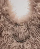 Bolso de mano de efecto pelo en color tostado, con diseño triangular, asa de hombro integrada y detalle de aro metálico frontal.