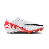 Championes de fútbol Nike Mercurial Vapor 15 Elite FG, color blanco con detalles en rojo y negro. Presentan tecnología Flyknit y unidad Air Zoom en la suela para mayor reactividad.