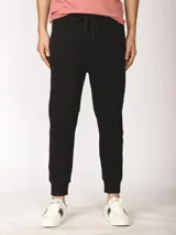 Pantalón de jogging negro, corte slim, con cordón ajustable en la cintura y puños elastizados en los tobillos. Presenta paneles cosidos a la altura de las rodillas.