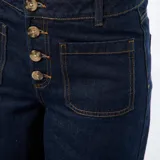 Pantalón de jean azul oscuro con corte wide leg, cintura alta y cierre frontal con botones a la vista. Presenta bolsillos frontales tipo parche.