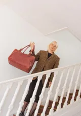 Bolso de mano tipo shopper marca Amadea, confeccionado en cuero con acabado desgastado. Presenta detalles de costuras decorativas verticales, correas con hebillas metálicas doradas y logo grabado al frente.