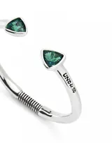 Pulsera rígida de aleación de metales bañada en plata de ley, con dos cristales facetados verdes en forma triangular en los extremos.