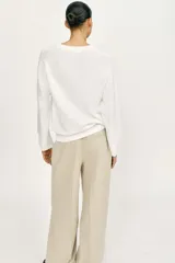 Sweater de punto color blanco, con amplio escote redondo y manga larga, con terminaciones en rib.
