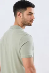 Remera polo de manga corta en color azul melange, con cuello camisero, cierre frontal de dos botones y pequeño bordado en el pecho.